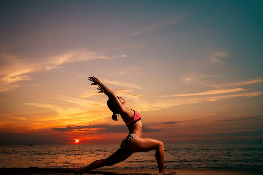 woman doing yoga on the beach