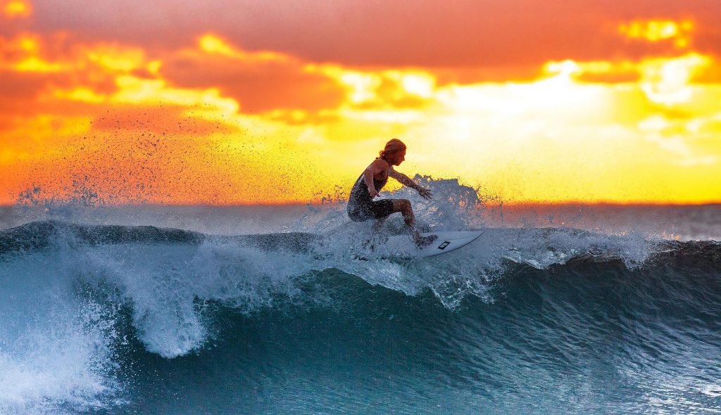 Surfing with a backdrop of sunset