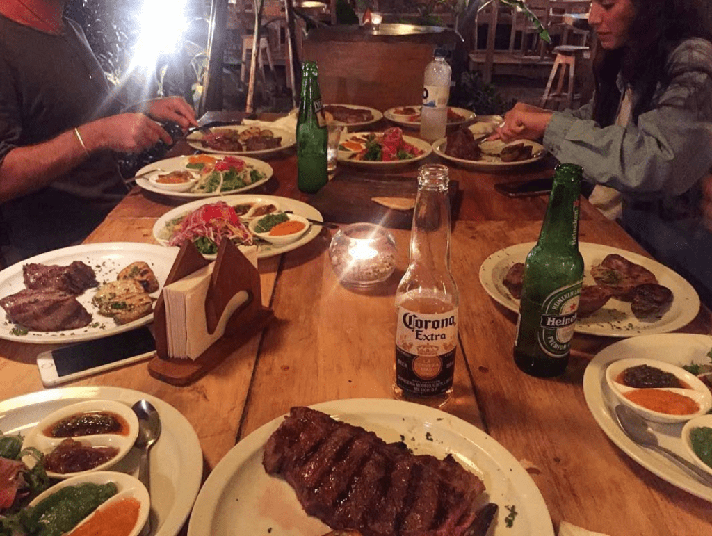 Beer and steak on a table with diners in the background