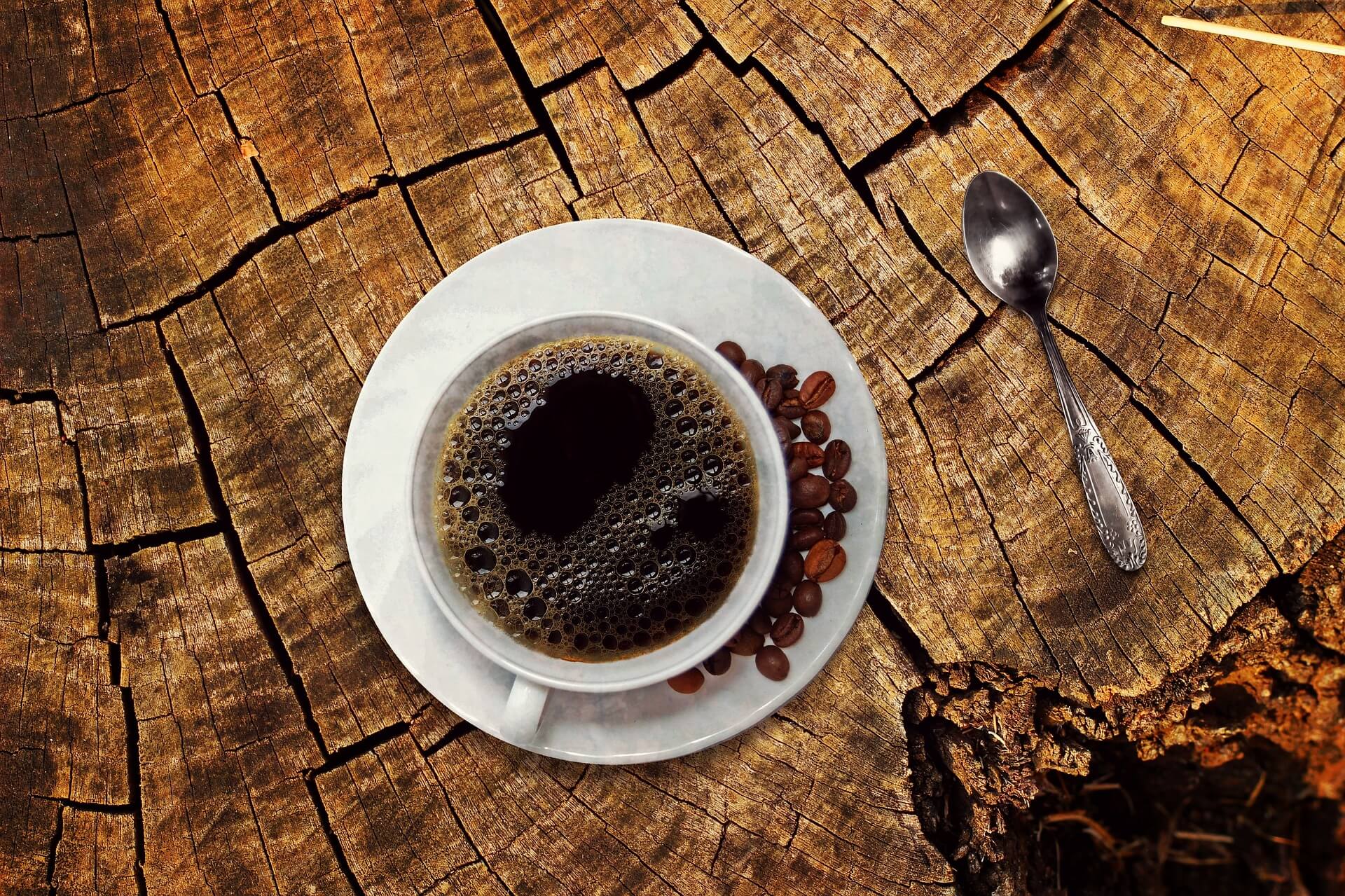 A cup of black coffee on a tree trunk table