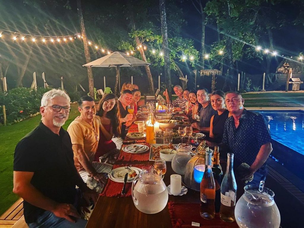 A group of people enjoying beachfront dining at Casa Teresa in the nighttime