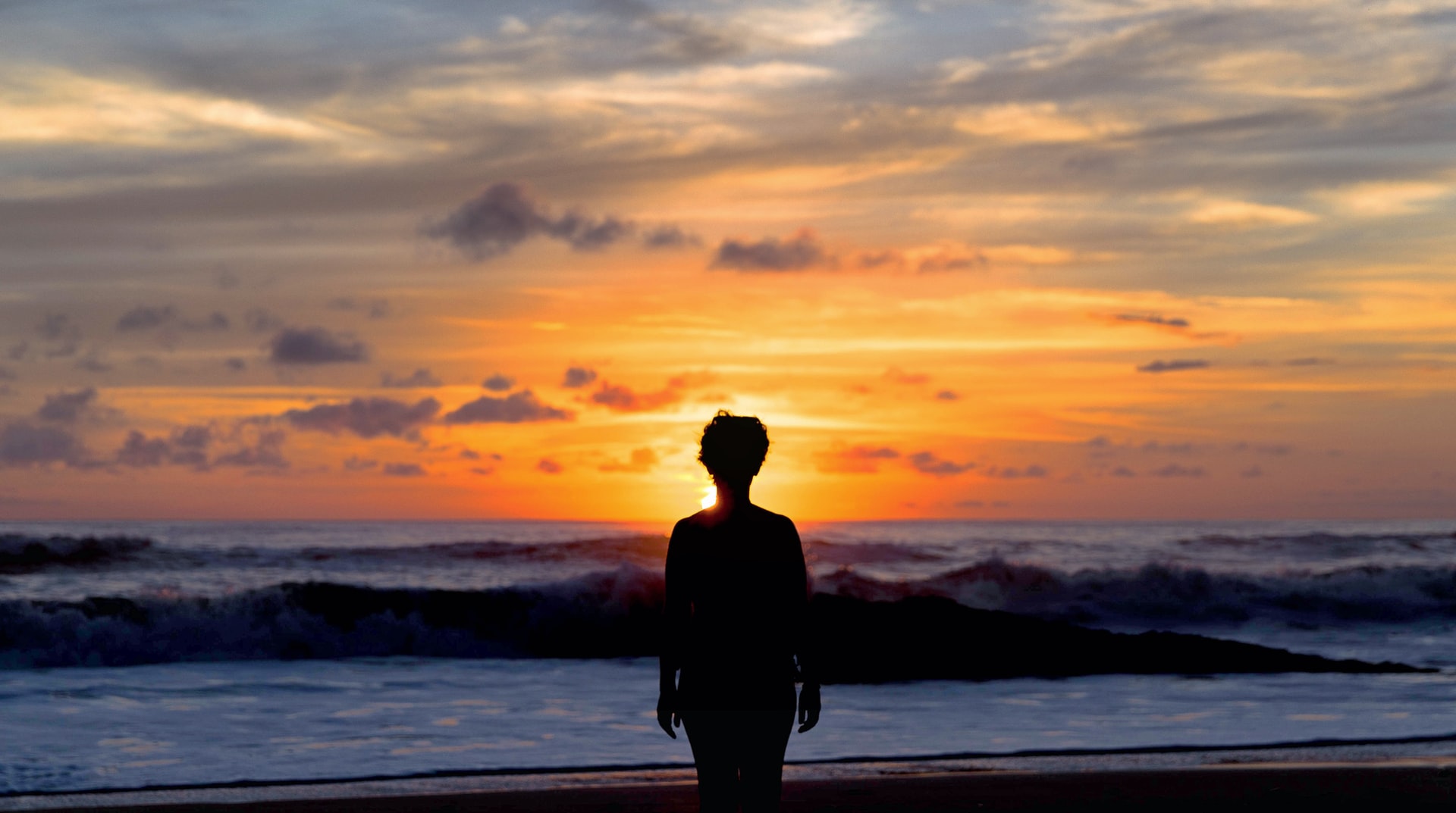 Person standing on the beach in Santa Teresa, Costa Rica at sunset