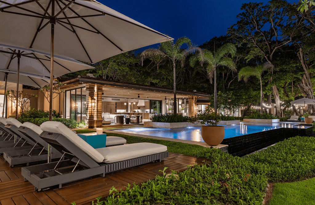 Villa pool under palm trees at night