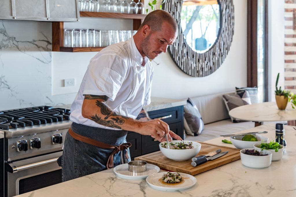 Casa Teresa’s private chef Jim preparing a custom-made meal for villa guests on a marble kitchen island