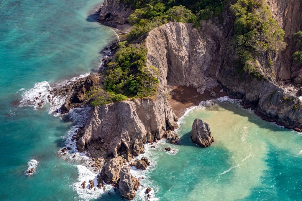 Aerial shot of the cliffs at Tortuga Island in Costa Rica during a chartered flight daytrip from the Nicoya Peninsula