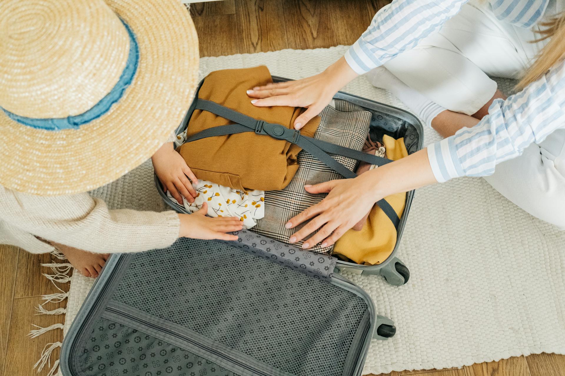 Top view of a mother and child packing a suitcase together