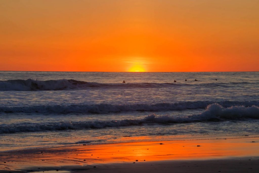 Surfers on waves at sunset in Costa Rica