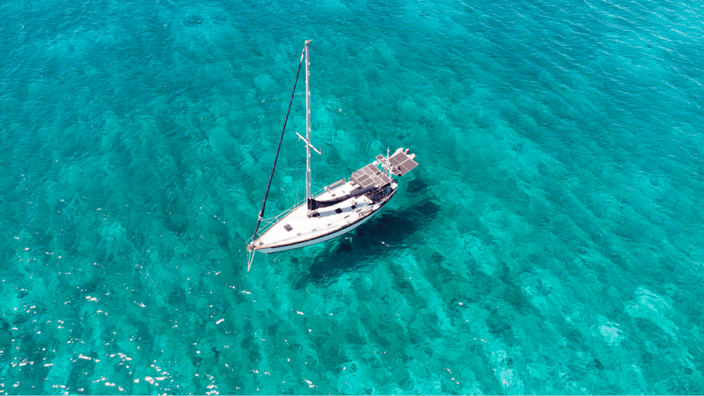 Sailboat floating in crystal clear blue waters in Costa Rica