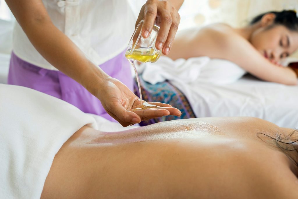 Masseuse pouring body oil in their hand and person lying down during a spa treatment in Costa Rica