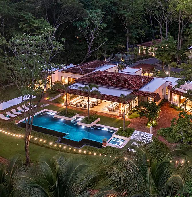 Aerial view of Casa Teresa Grande villa lit up at dusk.