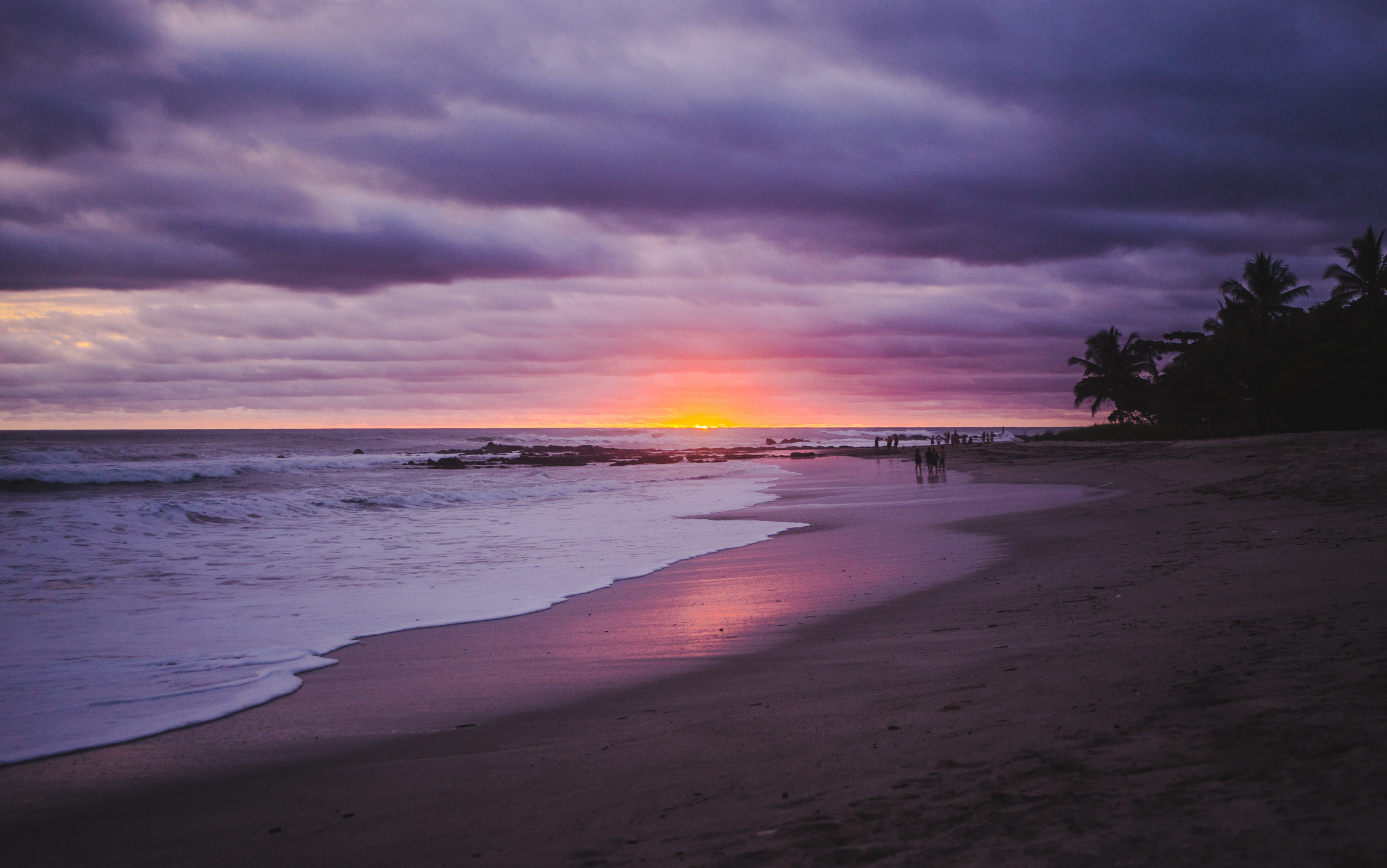 Twilight on Santa Teresa’s coastline with people strolling along the beach