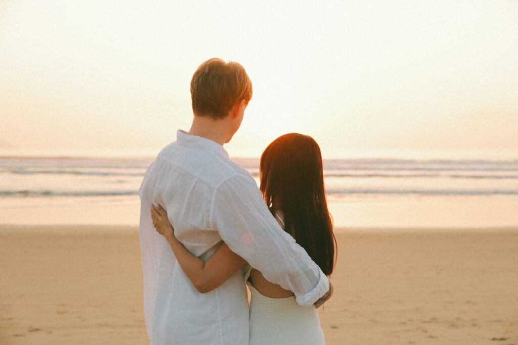 Couple embracing on beach at sunset during their Costa Rica honeymoon