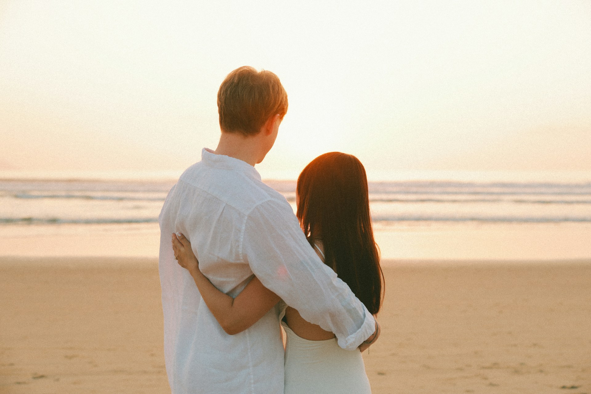 Couple embracing on beach at sunset during their Costa Rica honeymoon