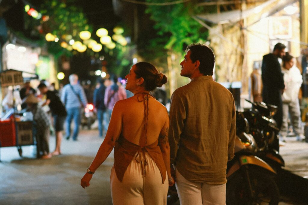Couple walking through a lively street at night