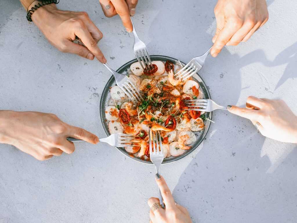 Group of people enjoying a gourmet shrimp dish together